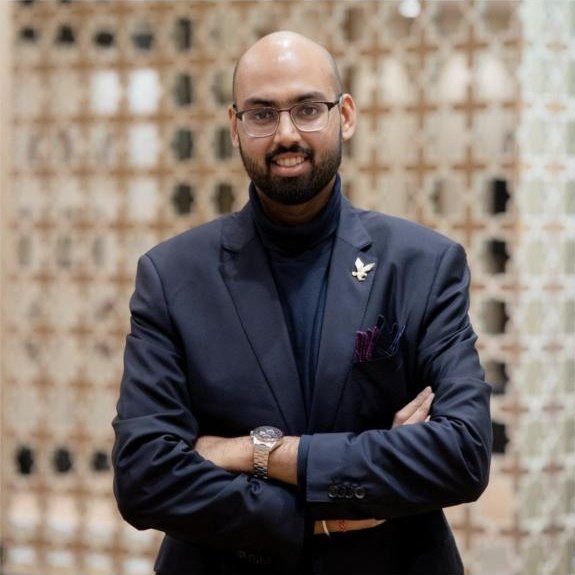 Sharan Aggarwal, angel investor, in a navy suit with arms folded